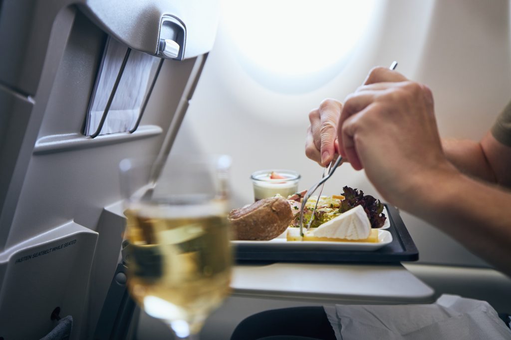 Airline meal and beverage served on seat tables during flight.