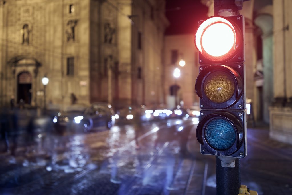 Red light on traffic lights against crosswalk. Night scene of city street in Prague, Czech Republic.